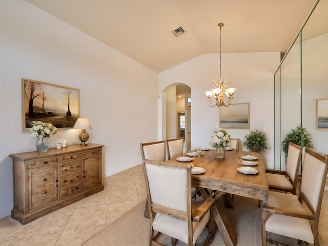 tiled dining space featuring a notable chandelier and vaulted ceiling