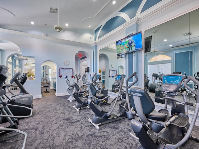 workout area with a high ceiling, crown molding, and a textured ceiling