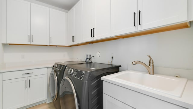 laundry room with separate washer and dryer, sink, and cabinets