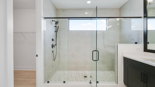 bathroom with an enclosed shower, vanity, and wood-type flooring