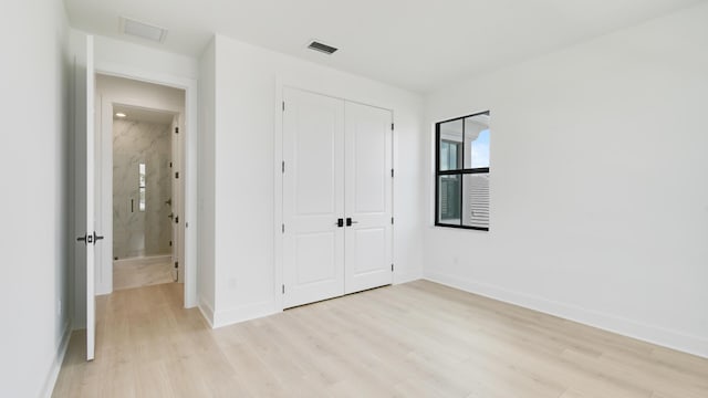 unfurnished bedroom featuring light hardwood / wood-style floors and a closet