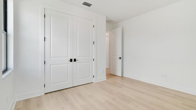 unfurnished bedroom featuring light hardwood / wood-style floors and a closet