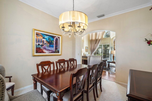 carpeted dining area with crown molding and a notable chandelier