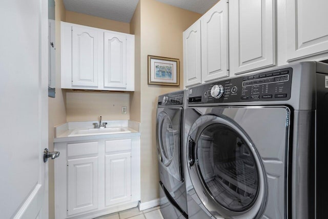 clothes washing area featuring cabinets, washing machine and dryer, sink, and a textured ceiling