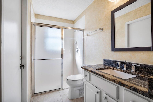 bathroom featuring toilet, a shower with shower door, a textured ceiling, vanity, and tile patterned flooring