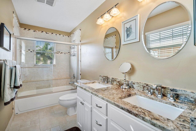 full bathroom with bath / shower combo with glass door, vanity, and toilet