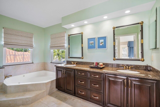 bathroom with vanity and tiled tub