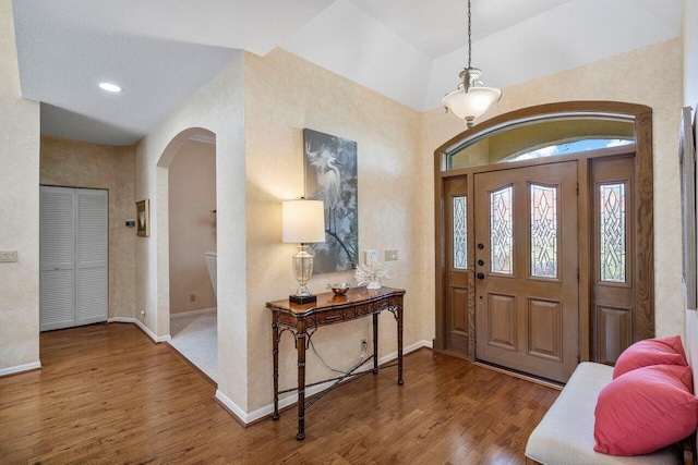 foyer with vaulted ceiling and hardwood / wood-style floors