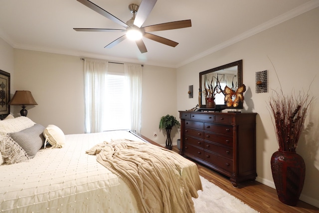 bedroom with ornamental molding, hardwood / wood-style floors, and ceiling fan