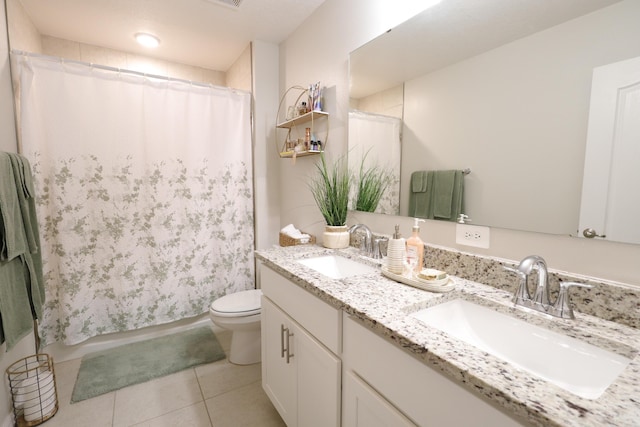 bathroom featuring tile patterned flooring, vanity, toilet, and walk in shower