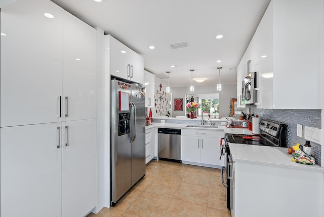 kitchen with decorative light fixtures, white cabinetry, sink, kitchen peninsula, and stainless steel appliances