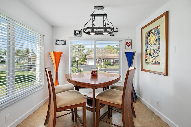 dining area featuring light tile patterned floors and a notable chandelier