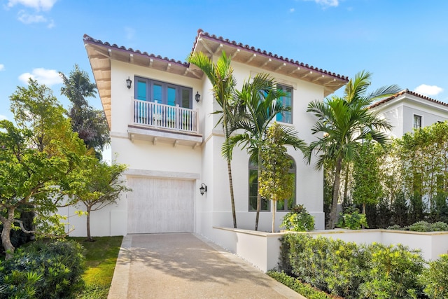 mediterranean / spanish-style house with a garage and a balcony