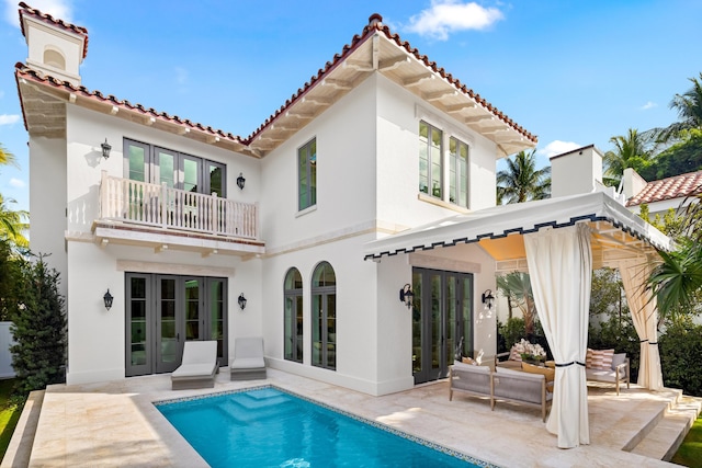 back of property with a patio, a balcony, and french doors