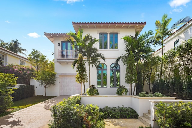 mediterranean / spanish home featuring a garage and a balcony