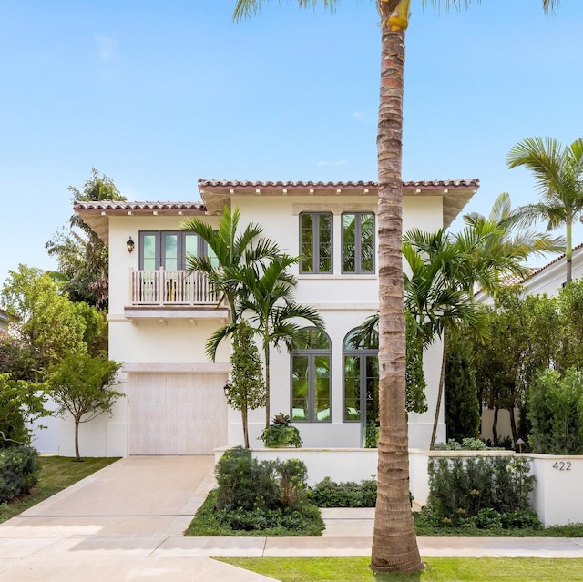 mediterranean / spanish house featuring a garage and a balcony