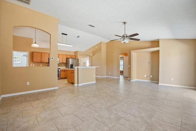 unfurnished living room with ceiling fan, lofted ceiling, a textured ceiling, and light tile patterned floors