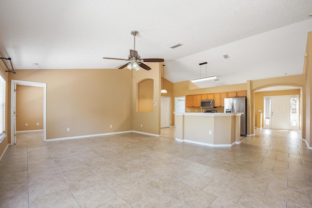 unfurnished living room with ceiling fan, lofted ceiling, and a wealth of natural light