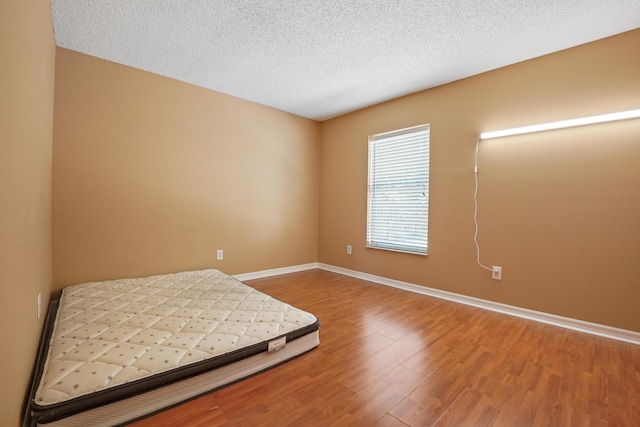 bedroom featuring wood-type flooring and a textured ceiling