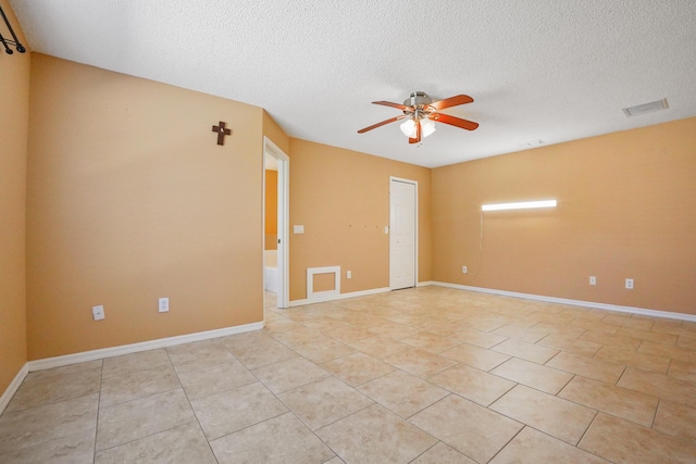 spare room with light tile patterned floors, a textured ceiling, and ceiling fan