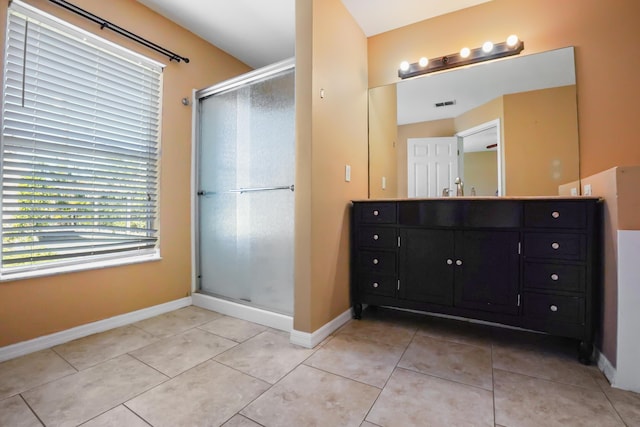 bathroom featuring vanity, a shower with shower door, and tile patterned flooring