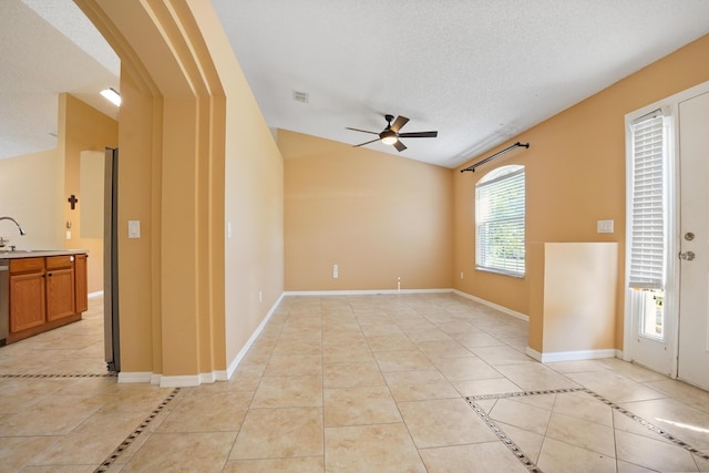 tiled spare room with sink, vaulted ceiling, a textured ceiling, and ceiling fan