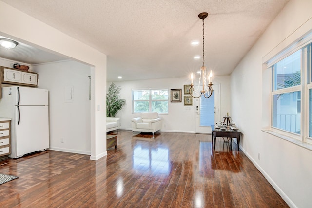 42 Burgundy Unit A, Delray Beach, FL 33484 - unfurnished dining area featuring dark wood-type flooring, an inviting chandelier, and a textured ceiling