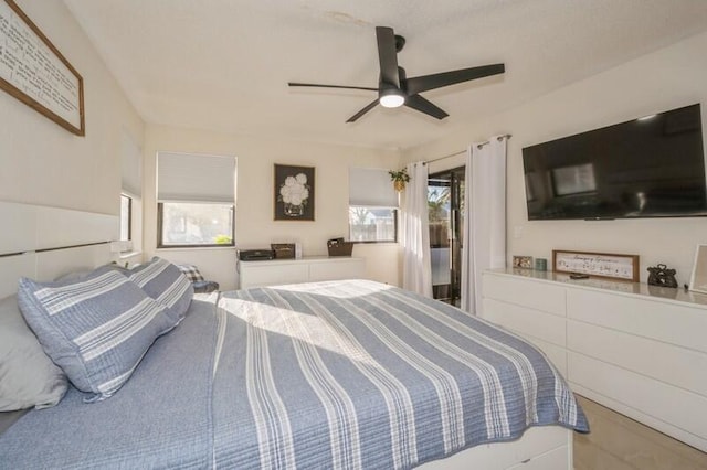 bedroom with multiple windows, access to exterior, and ceiling fan