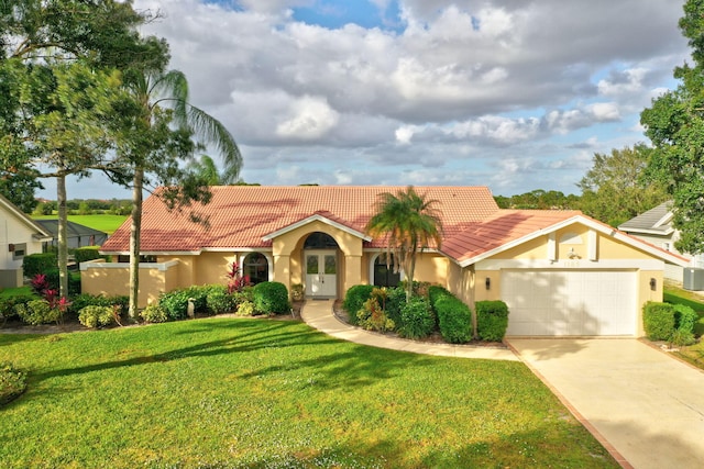 mediterranean / spanish-style home with a garage and a front lawn