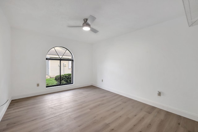 empty room with ceiling fan and light hardwood / wood-style flooring