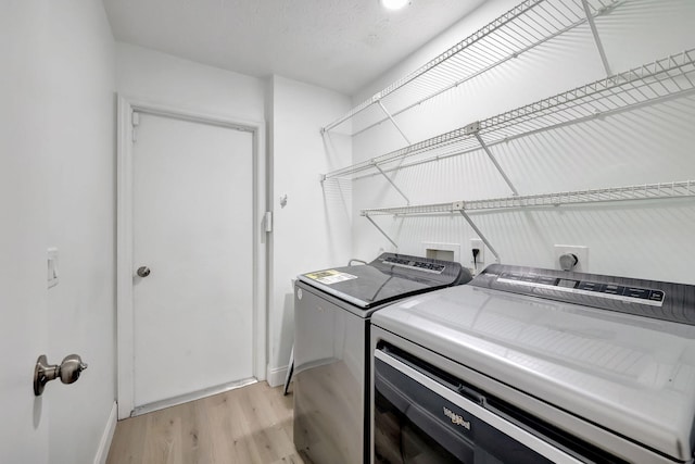 laundry area featuring independent washer and dryer and light wood-type flooring