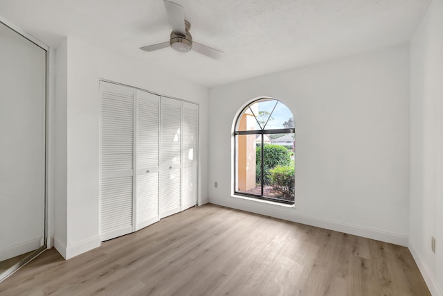 unfurnished bedroom with ceiling fan, light hardwood / wood-style floors, and a closet