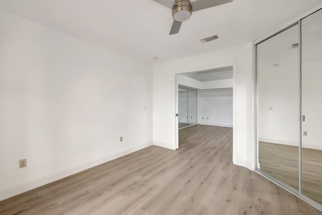 empty room with ceiling fan and light hardwood / wood-style floors