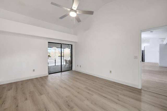 empty room featuring ceiling fan, lofted ceiling, and light wood-type flooring