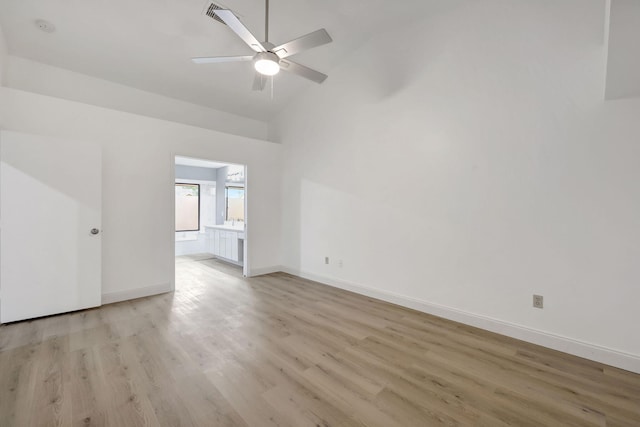 empty room featuring ceiling fan, high vaulted ceiling, and light hardwood / wood-style flooring