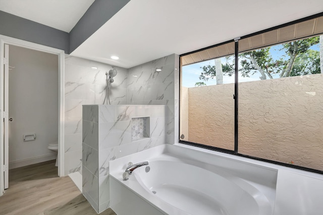 bathroom featuring hardwood / wood-style flooring, a wealth of natural light, and separate shower and tub