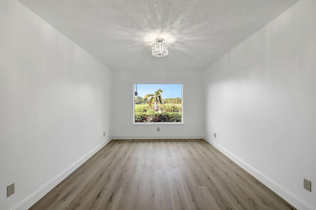 unfurnished room with a textured ceiling and light hardwood / wood-style flooring