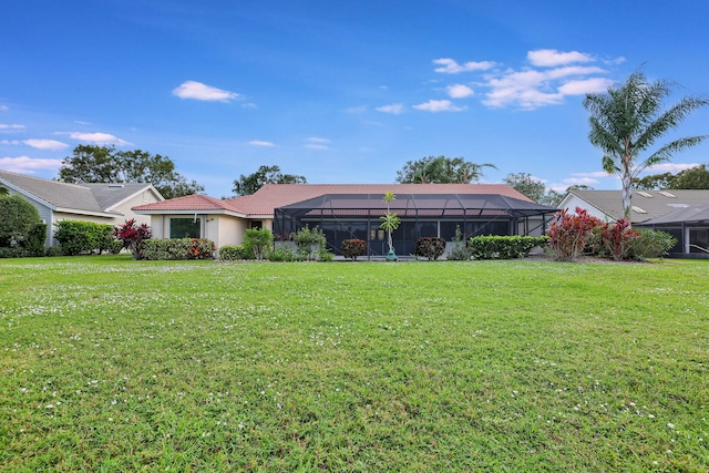 view of front facade with a front yard and glass enclosure