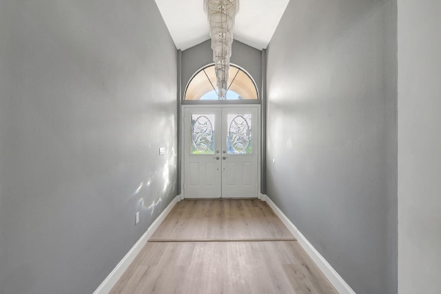 doorway to outside featuring high vaulted ceiling and light wood-type flooring