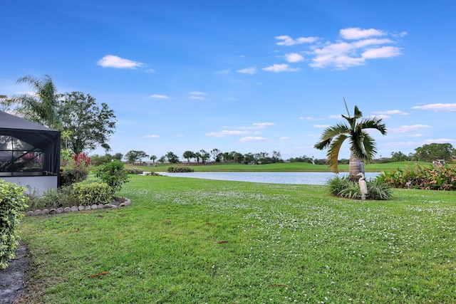 view of yard with a lanai and a water view