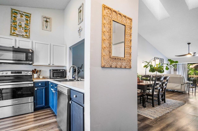 kitchen featuring blue cabinets, sink, white cabinets, dark hardwood / wood-style flooring, and stainless steel appliances