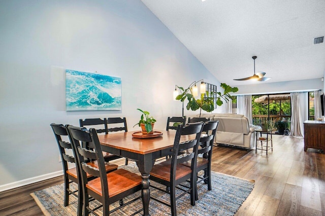 dining room with dark wood-type flooring, high vaulted ceiling, and ceiling fan