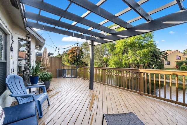 deck with a water view and a pergola