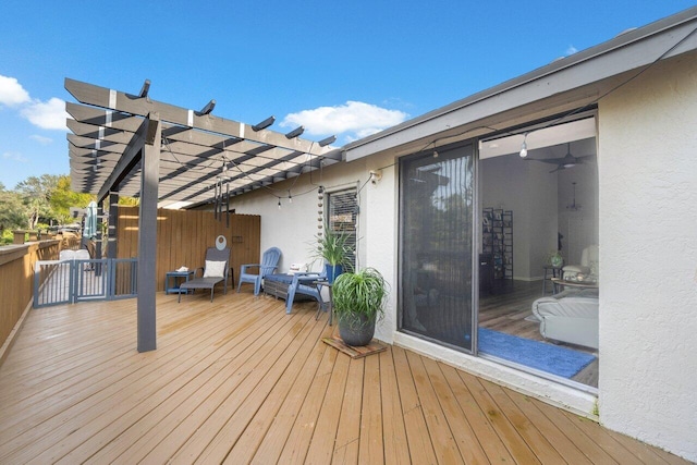 deck featuring ceiling fan and a pergola