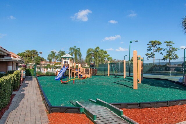 view of jungle gym featuring tennis court