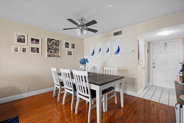 dining space with hardwood / wood-style floors and a textured ceiling