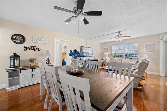 living room with ceiling fan, dark wood-type flooring, and a textured ceiling