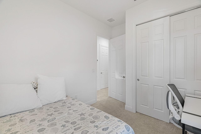 bedroom with light colored carpet and a closet