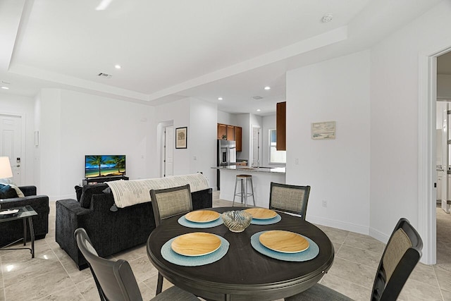 dining space with a raised ceiling