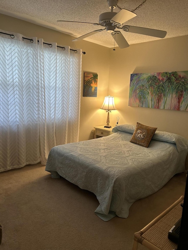 bedroom with carpet, a textured ceiling, and ceiling fan